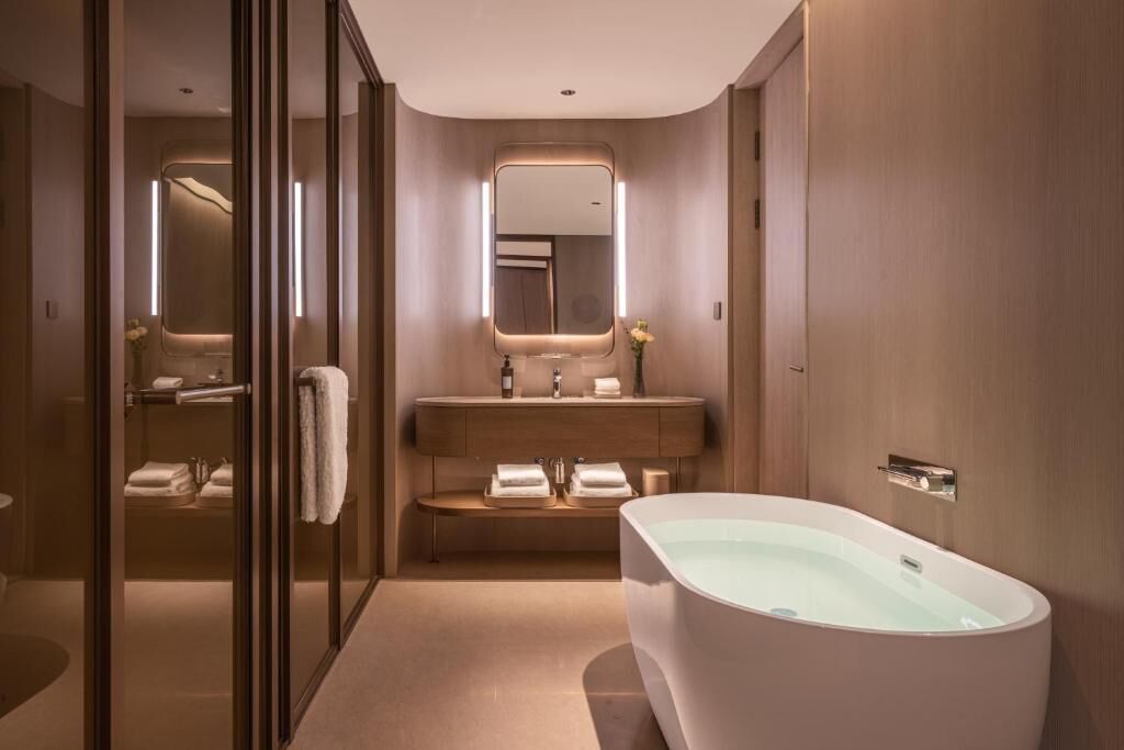 Un baño moderno con una bañera independiente, un tocador con espejo y una zona de ducha.