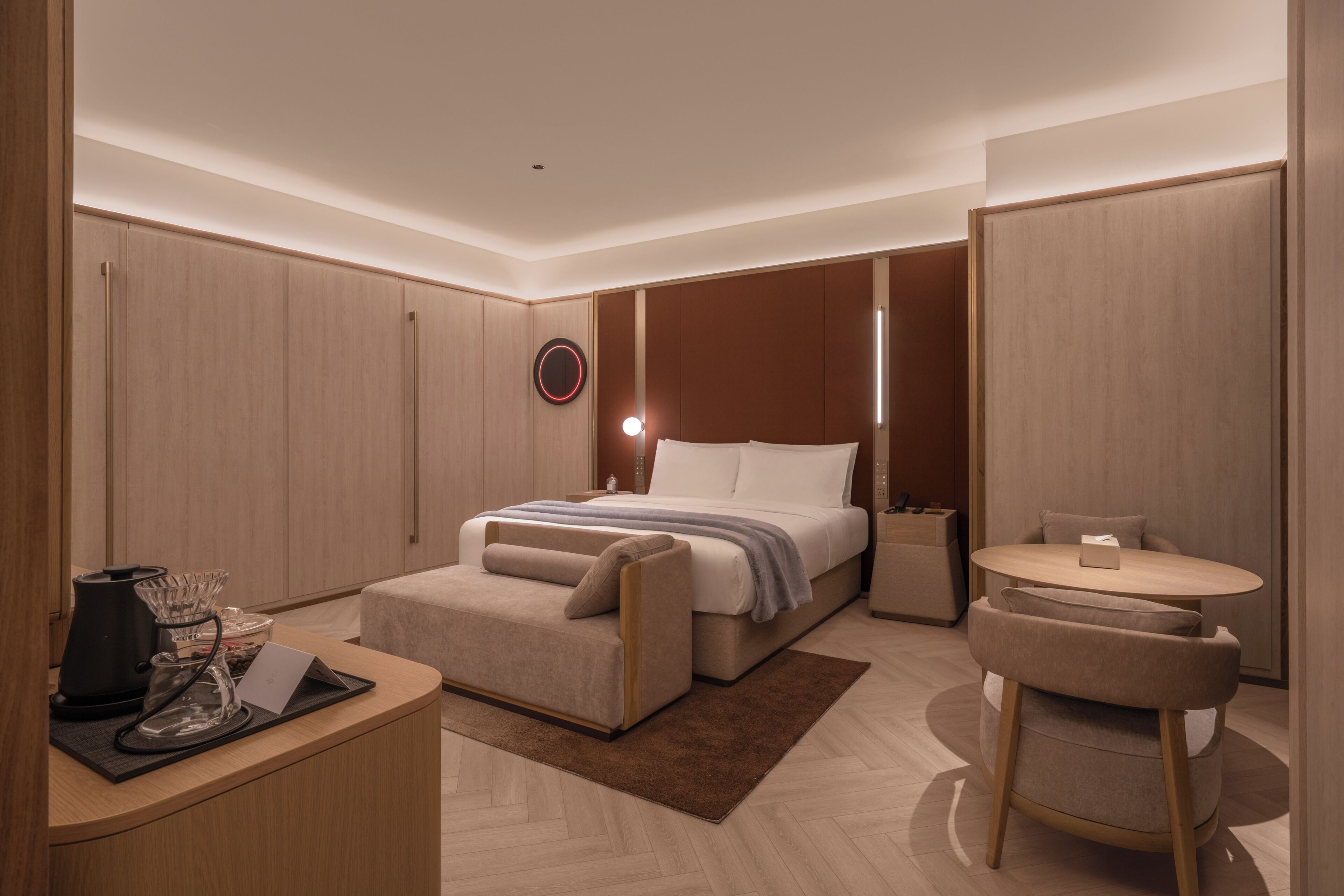 Ein modernes Hotelzimmer mit Bett, Nachttischen, Schreibtisch und Stuhl.