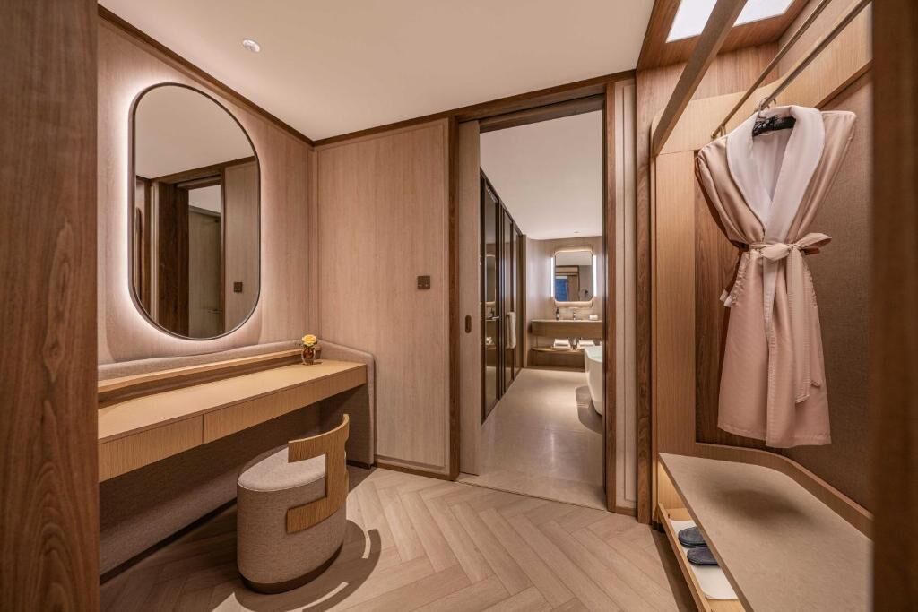 A modern bathroom with a vanity, mirror, and robe hanging on the wall.