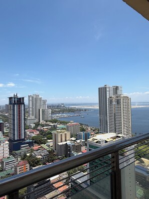 A high-rise building with a view of a cityscape and a body of water. - JFS Cozy 1-bedroom Staycation in beautiful Manila - Near US Embassy (Manila)