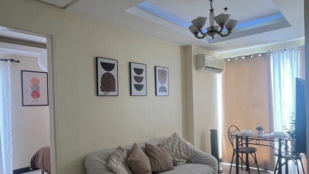 Ein Wohnzimmer mit einer Couch, einem Couchtisch und einem Essbereich mit Stühlen.
