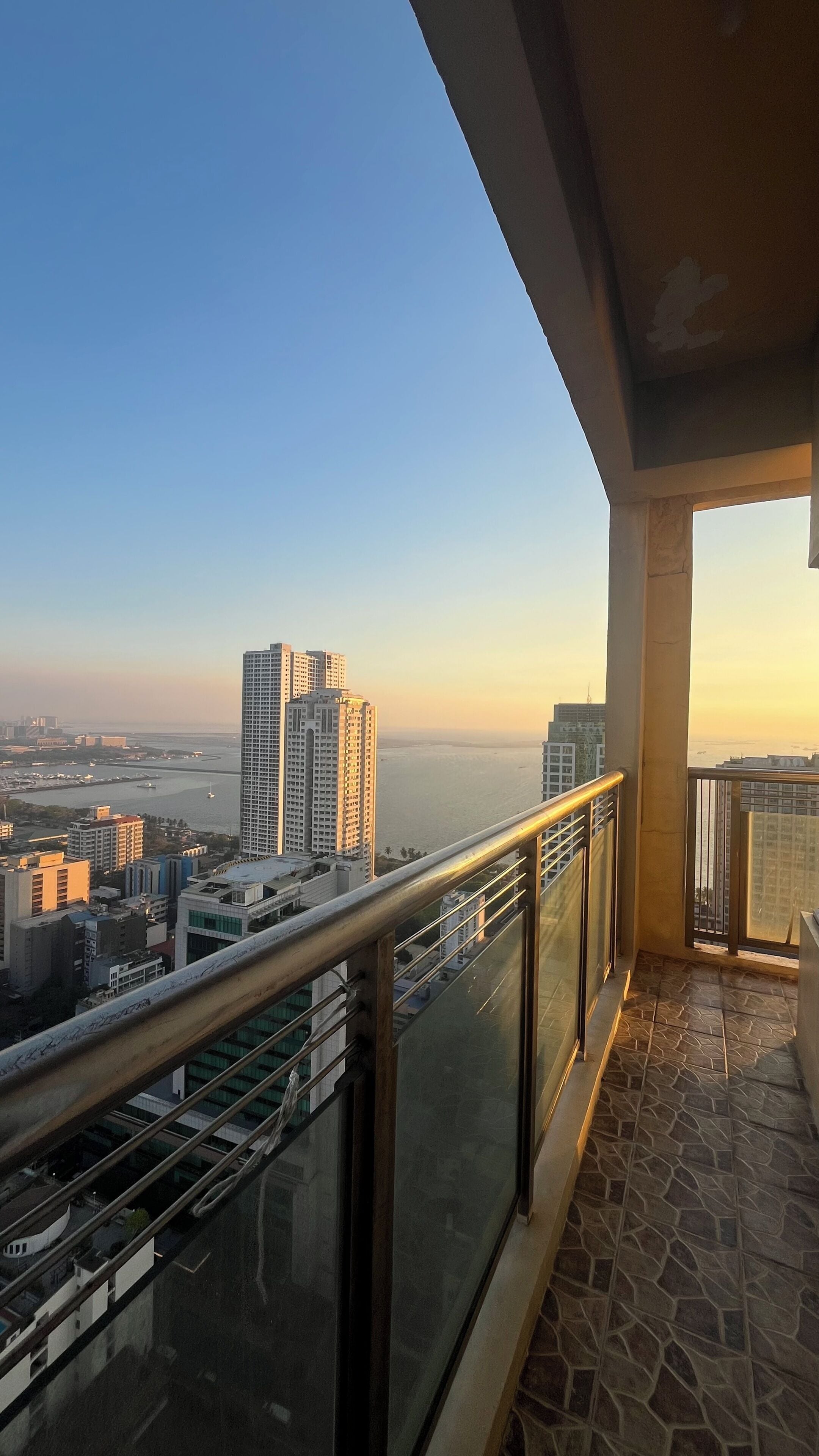 A balcony with a view of a cityscape and a body of water.