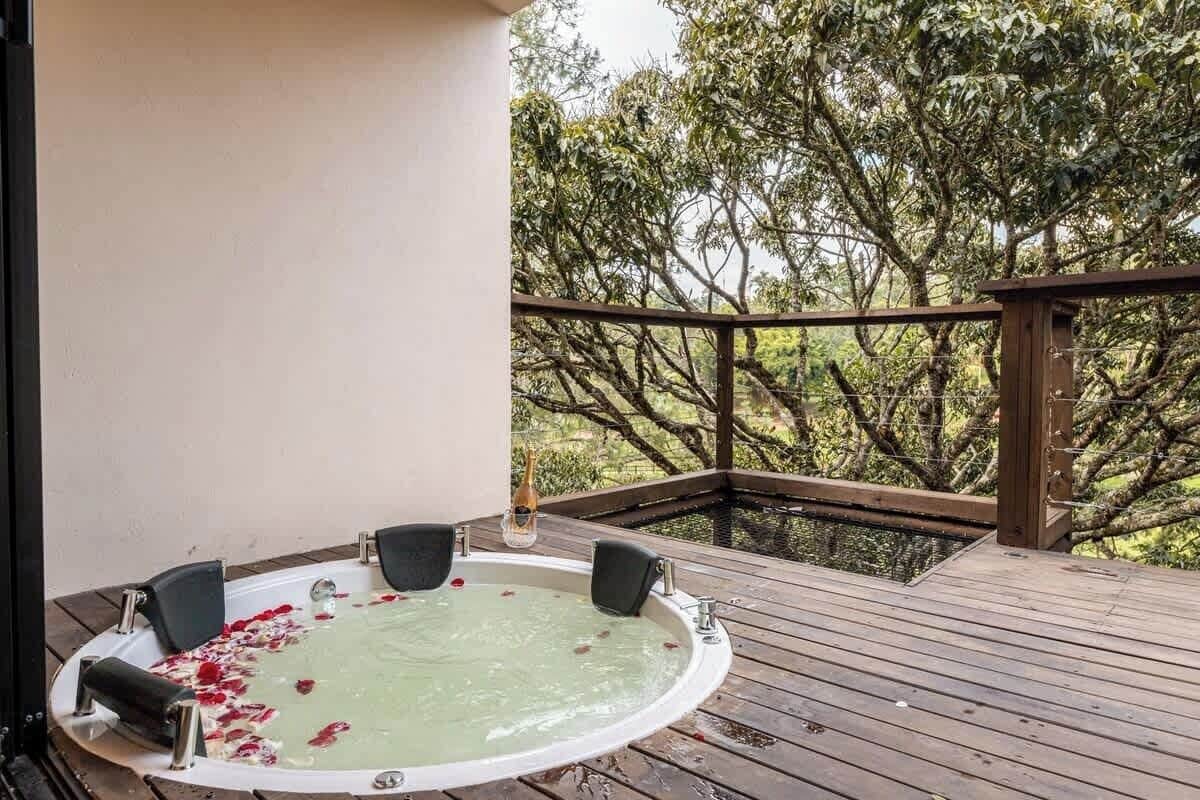 A hot tub on a wooden deck with a view of trees.