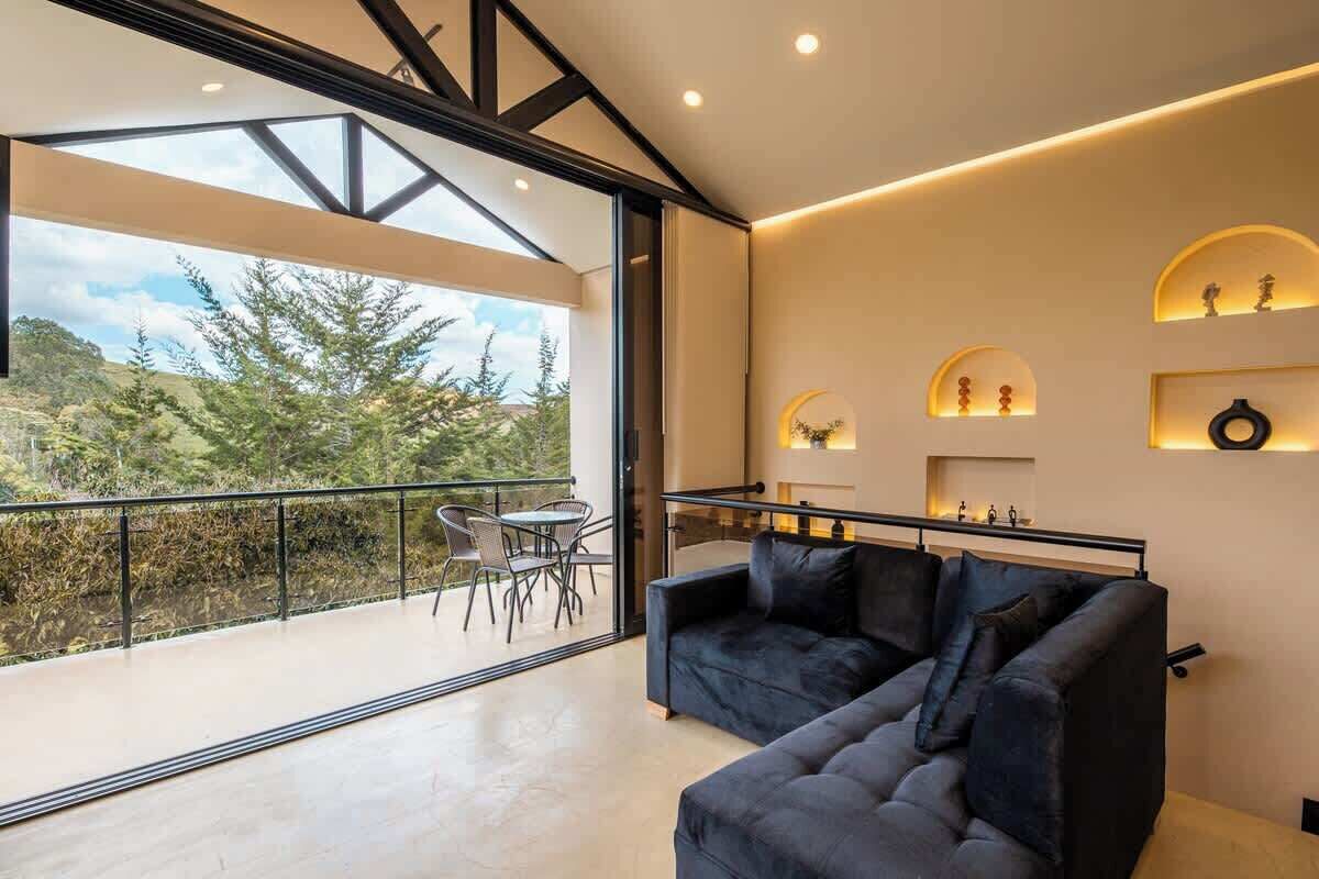 Um interior moderno com varanda, sofá e prateleiras fixadas na parede.