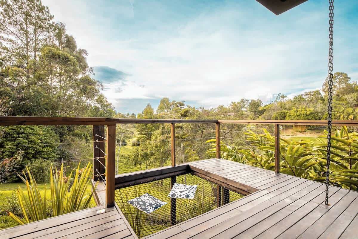 A wooden deck with a view of a lush garden and trees.