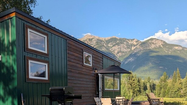 A cabin with a deck, outdoor seating, and a grill. - Nicholson Tiny Home with Hot Tub & Mountain Views (Golden)