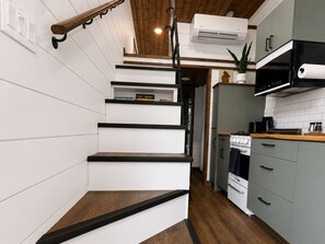 A kitchen with a built-in stove, a microwave, and a coffee maker on the countertop. - Nicholson Tiny Home with Hot Tub & Mountain Views (Golden)
