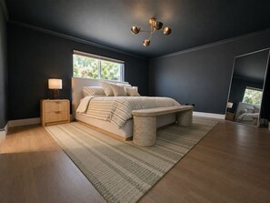 A modern bedroom with a bed, bedside tables, a large mirror, and a ceiling light fixture. - Luxurious modern estate minutes from Disney (Davenport)