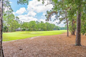 A golf course with a clubhouse, trees, and a clear sky. - The Fairway Retreat on Pinehurst #5! (Pinehurst)