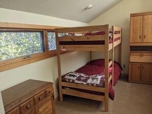 A bunk bed with a window above, a wooden dresser, and a wooden cabinet. - Tree house steps from the river (Bend)