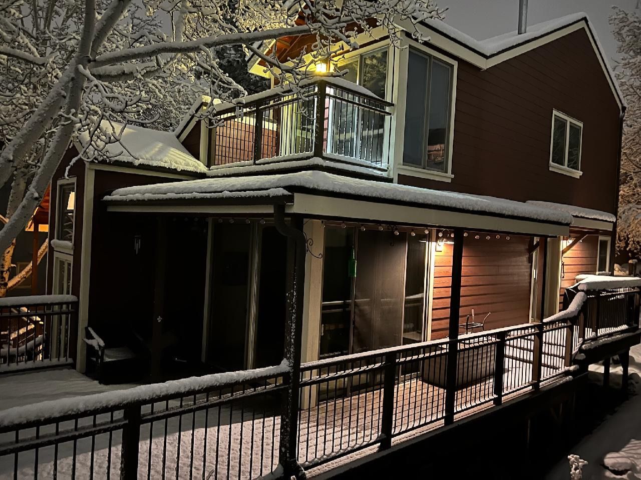 A two-story house with a balcony and a covered deck area.