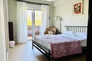 A bedroom with a bed, a chair, a desk, and a window with curtains. - Bright City Flat Close to Acropolis Museum (Athens)