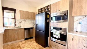 Eine moderne Küche mit eingebautem Geschirrspüler, einer Kühlschrank mit zwei Türen, einer Mikrowelle und einem Backofen.