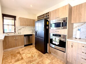 A modern kitchen with a built-in dishwasher, double-door refrigerator, microwave, and oven. - Luxury Oceanfront 3BR Condo with Huge Terrace, Private Plunge Pool & Ocean Views (Playa del Carmen)