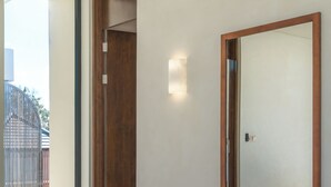 A modern gym with a bench, dumbbells, and a large mirror. - NAVA - Contemporary 3BR Villa (Badung)