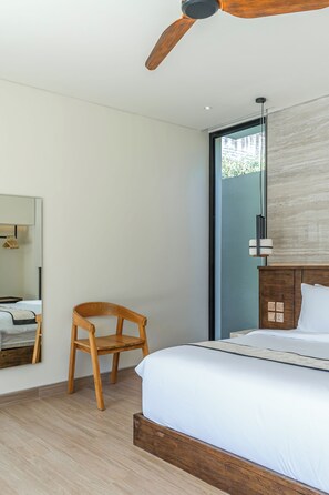 Un dormitorio moderno con una cama y una silla de madera, un ventilador de techo y un espejo grande.