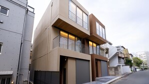 En moderne boligbygning i to etager med store vinduer, en altan og en garage.