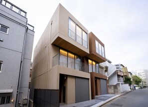 A modern two-story residential building with large windows, a balcony, and a garage. - ALMOND HOTEL SHIBUYA W (shibuya)
