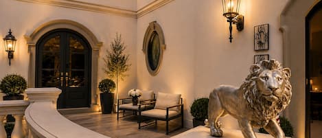 A grand entrance with a lion statue, elegant lighting, and classic architecture.