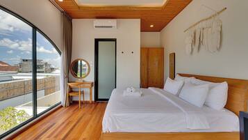 Une chambre d’hôtel avec une grande fenêtre, un lit, un bureau et une armoire.