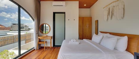 Une chambre d’hôtel avec une grande fenêtre, un lit, un bureau et une armoire.