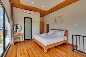 Een slaapkamer met een houten bed, een bureau en een groot raam.