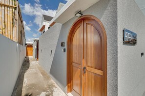 A narrow alleyway with a wooden door and a sign indicating 'The Ark Canggu'. - Villa Oliver - Canggu (Canggu)