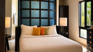 Un dormitorio con cama, ventilador de techo, ventana con vistas y mesita de noche con lámpara.