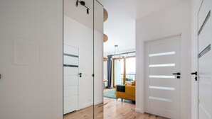 En modern inredning med trägolv, en soffa och en glasdörr.