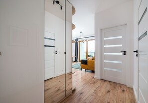 Ein modernes Interieur mit Holzboden, einer Couch und einer Glastür.