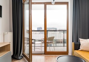 Una sala de estar moderna con un ventanal corredero que da a un balcón exterior.