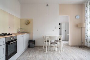 Eine kompakte Küche mit Gasherd, Backofen und einer kleinen Essecke mit Tisch und Stühlen.