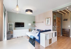 A modern bedroom with a bed, bedside table, TV, and a wooden wardrobe.