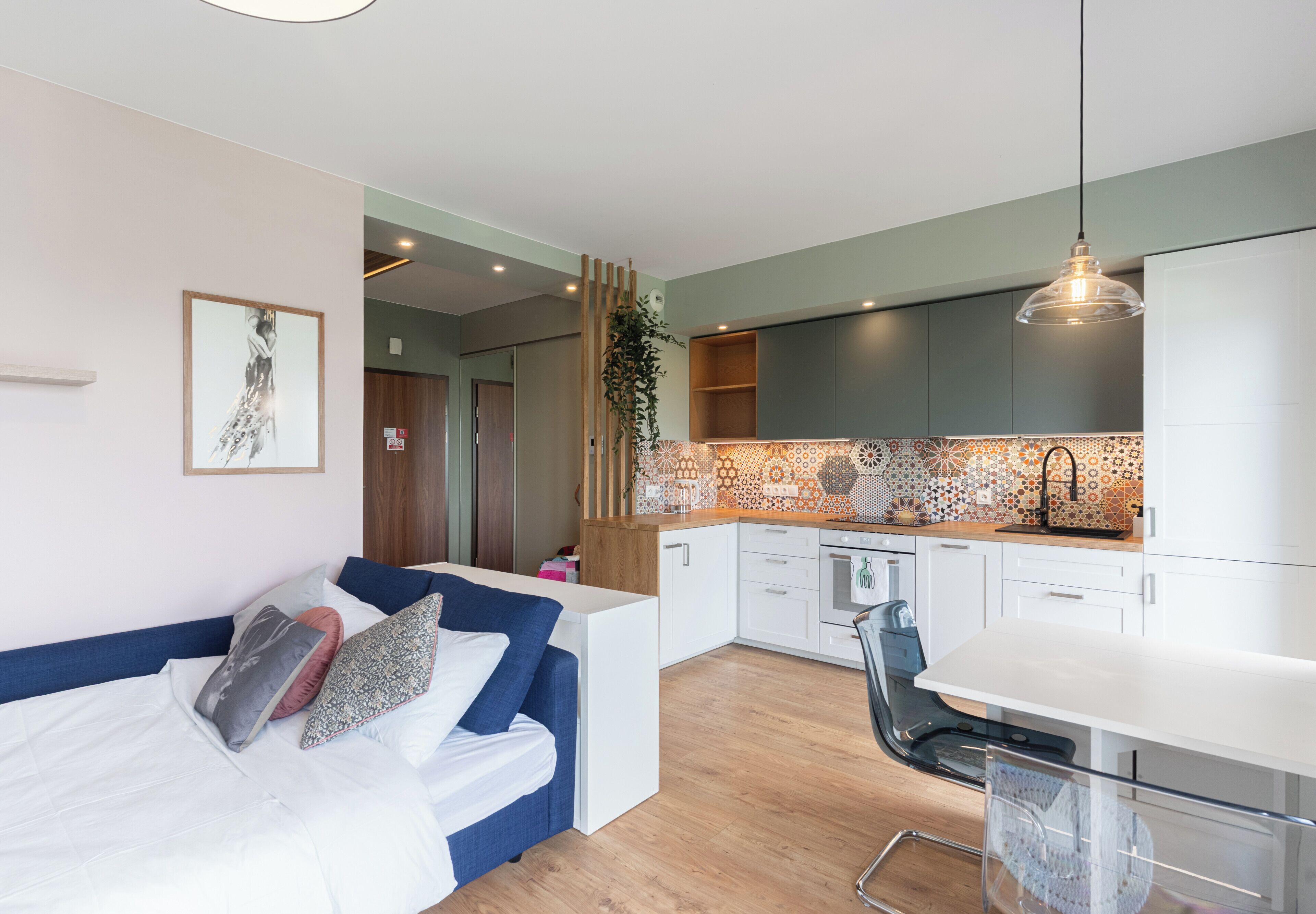 Een modern appartement met een woongedeelte, kitchenette en een eethoek.