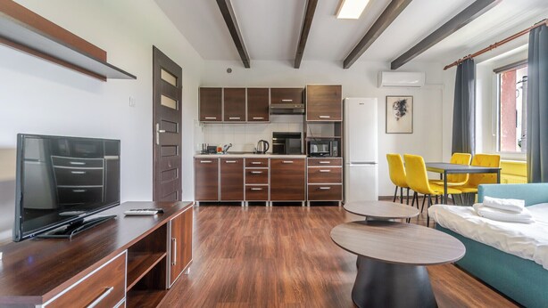 Una cocina moderna con armarios de madera y un comedor con sillas amarillas.