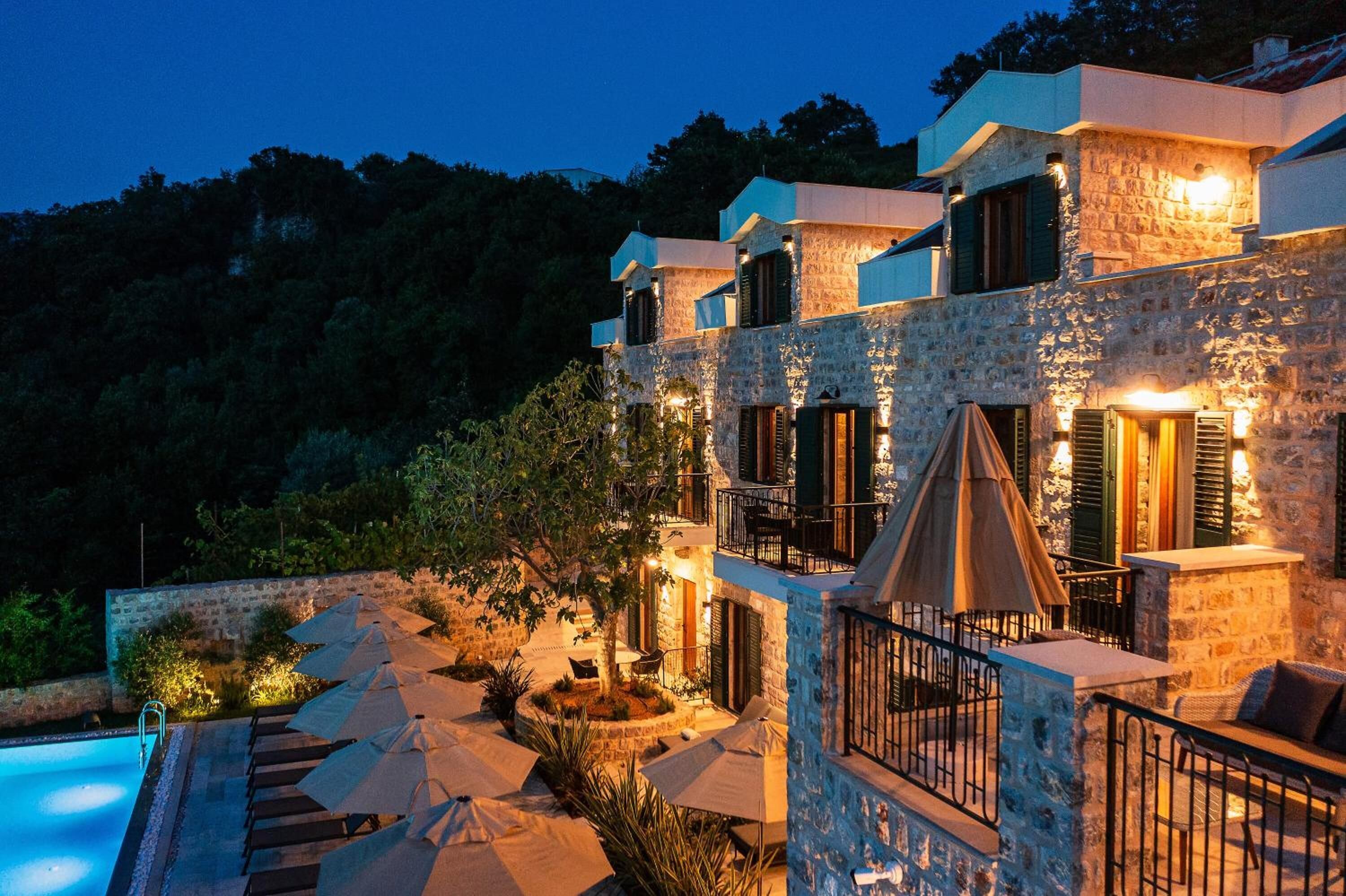 A stone building with outdoor seating and a pool.