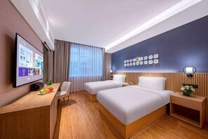 A hotel room with two beds, a desk with a flat-screen TV, a wall-mounted clock, and a window with curtains. - Crystal Hotel Beijing Chongwenmen (Beijing)