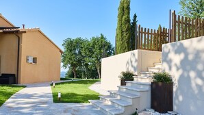 A residential area with a paved pathway leading to a set of stone steps, a wooden fence, and a building with a beige facade. - Villa Esther, 7 bedrooms, pool, A/C, EV charger, pet friendly, Marche (Fermignano)