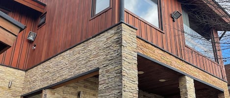 Ein modernes, zweistöckiges Haus mit Steinverkleidung und Holzfassade.