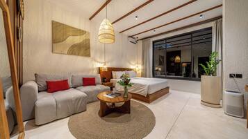 Una sala de estar moderna con un sofá, una mesa de centro y un ventanal grande.