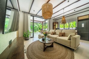Una sala de estar moderna con sofá, mesa de centro y lámparas colgantes.
