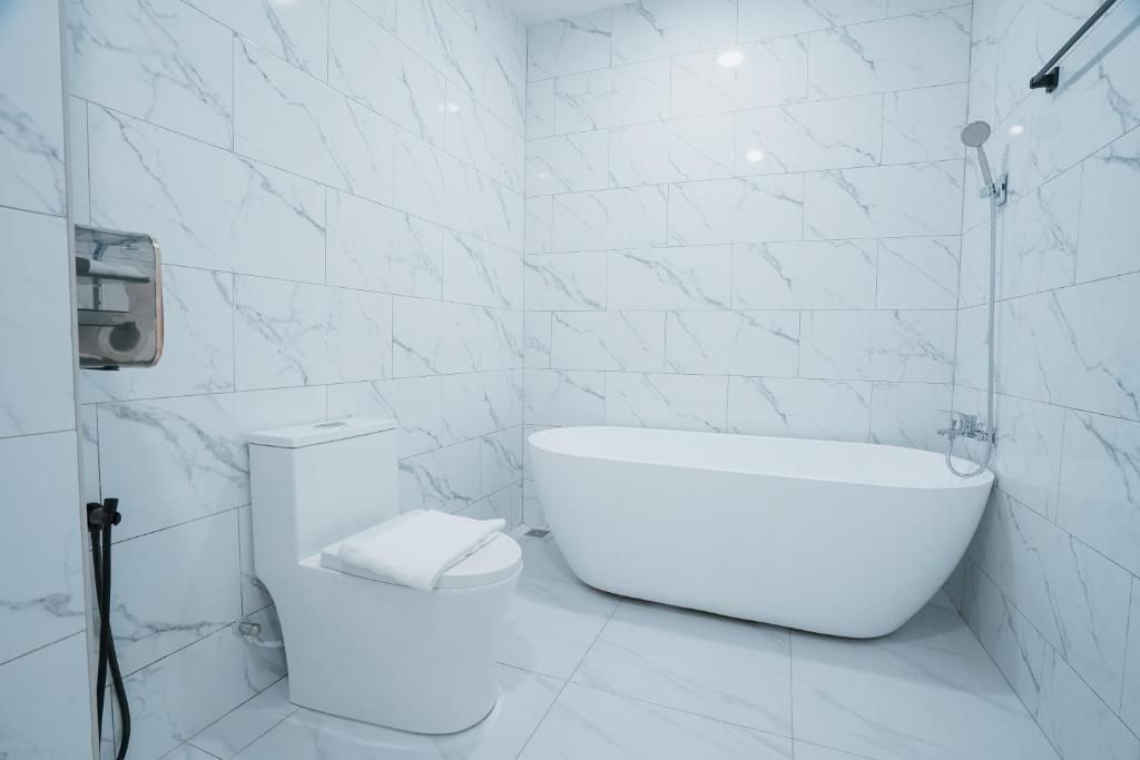 Un baño moderno con una bañera independiente, un inodoro y una zona de ducha.