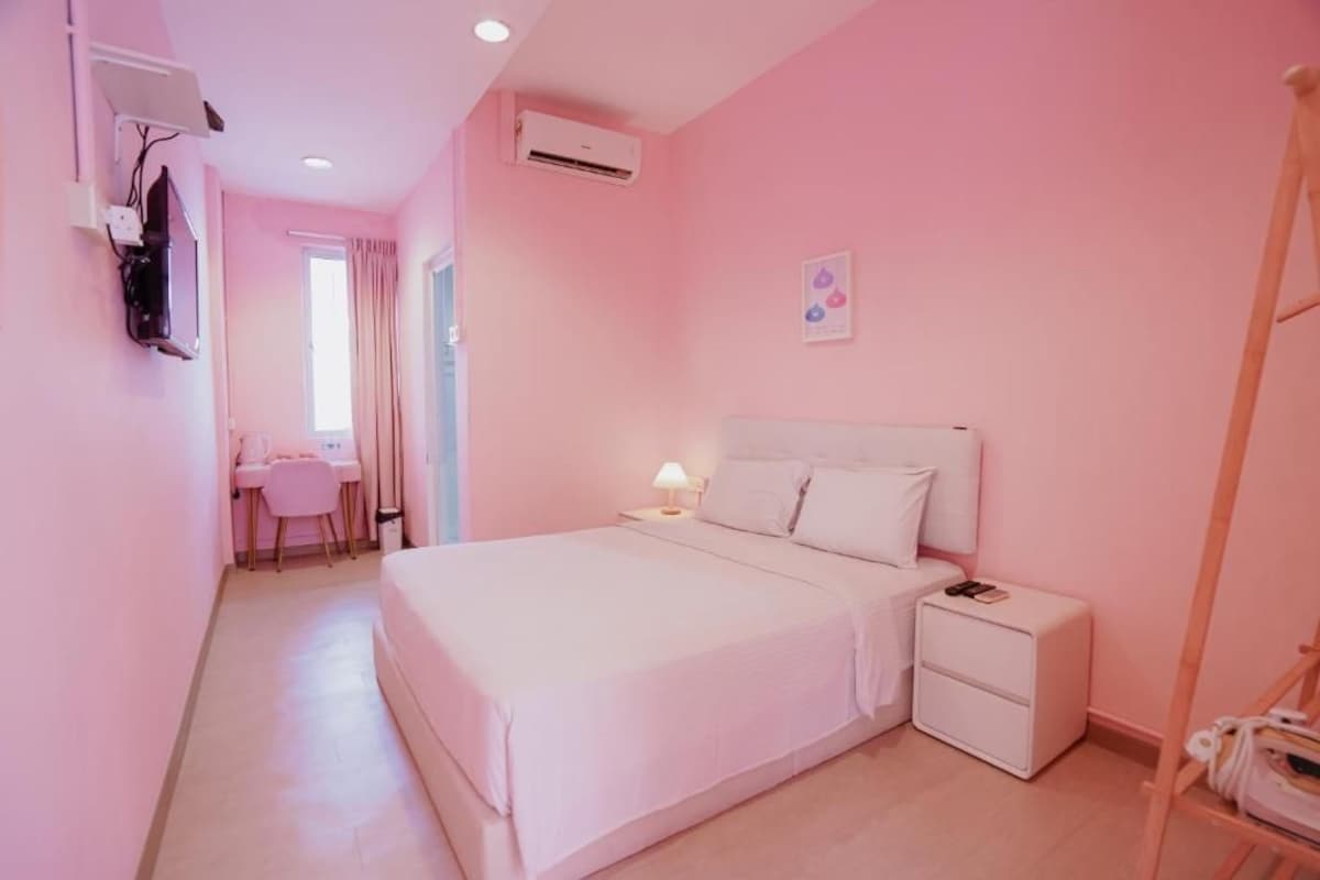 A bedroom with a bed, bedside tables, a desk, and a chair.