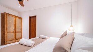 Une chambre à coucher avec un lit, une armoire en bois, une porte et un luminaire suspendu.