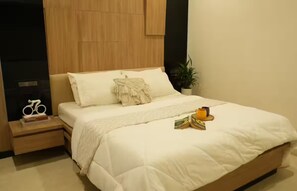 A bedroom with a bed, bedside table, and a nightstand.