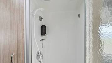 A bathroom with a shower, a toilet, and a sink.