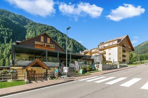 A hotel with a modern design, a covered outdoor area, and a mountain backdrop. - Ski In-Ski Out Apartment in Peio Val di Sole, Peio, Italy (Peio)