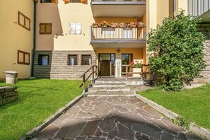 A stone staircase leading to a building entrance with a small garden area. - Ski In-Ski Out Apartment in Peio Val di Sole, Peio, Italy (Peio)