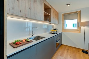 A modern kitchen with a built-in island, stainless steel sink, and wooden cabinets.