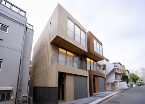A modern two-story residential building with large windows, a balcony, and a garage. - ALMOND HOTEL SHIBUYA F (Shibuya-ku)